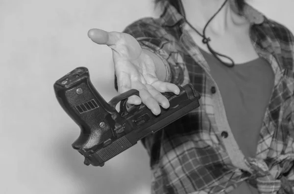 Flickan ger en pistol, svart och vitt — Stockfoto