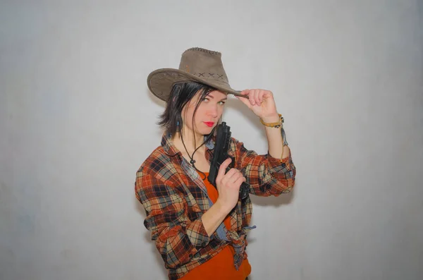 Sur un fond gris, la fille le cow-boy avec pistolet — Photo