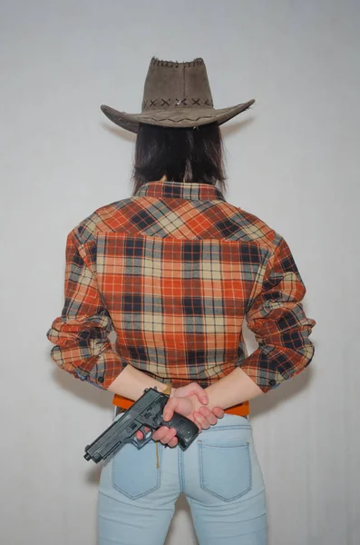 Dziewczyna kowboj z pistoletu, jest z powrotem, na szarym rynek — Zdjęcie stockowe