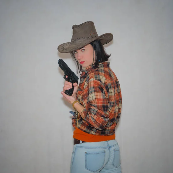La fille le cow-boy avec le pistolet, debout avec son dos clos — Photo