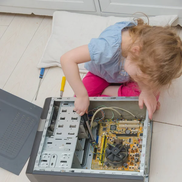 a child, a girl repairing a computer system unit