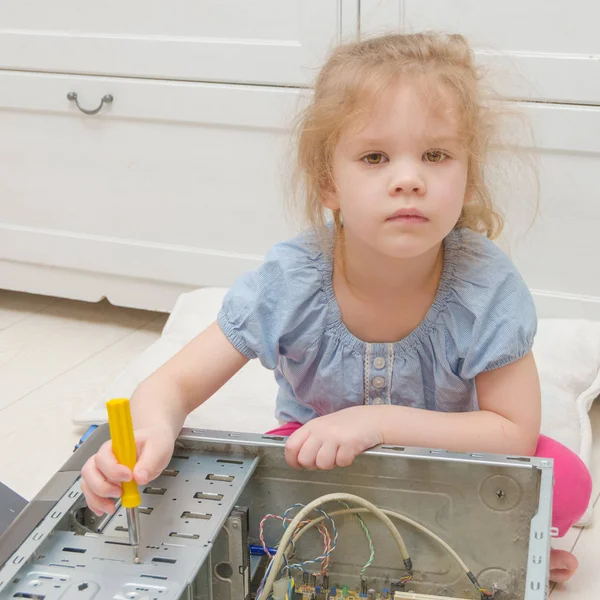 a child, a girl repairing a computer system unit