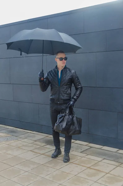 Homme brutal dans une veste et des lunettes de soleil dans la rue — Photo