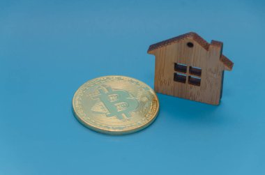 ahşap ev, oyuncak ve mavi bac üzerinde altın bitcoin cryptocurrency