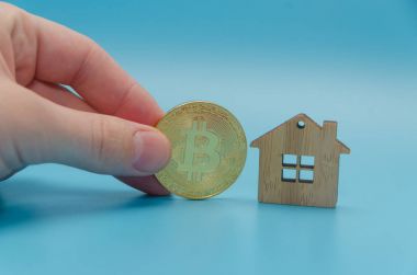 ahşap ev, oyuncak ve mavi bac üzerinde altın bitcoin cryptocurrency