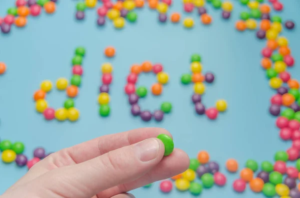 Caramelo caramelo alineado palabra dieta, sobre fondo azul, primer plano — Foto de Stock