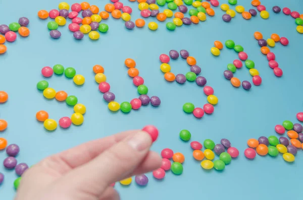 Nahaufnahme von Süßigkeiten Karamellzucker Diät ausgelegt, auf blauem Hintergrund — Stockfoto