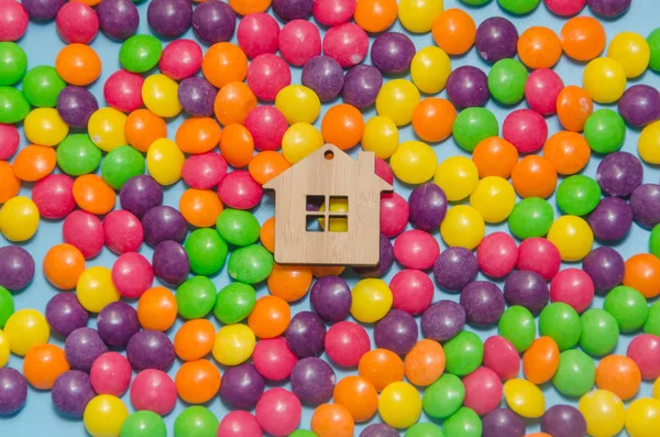 Fond bleu avec bonbons et maison jouet en bois — Photo