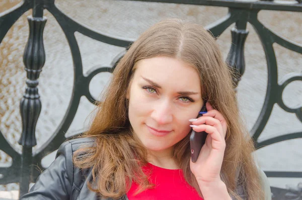 Niña en vestido y chaqueta de cuero con teléfono en la mano —  Fotos de Stock