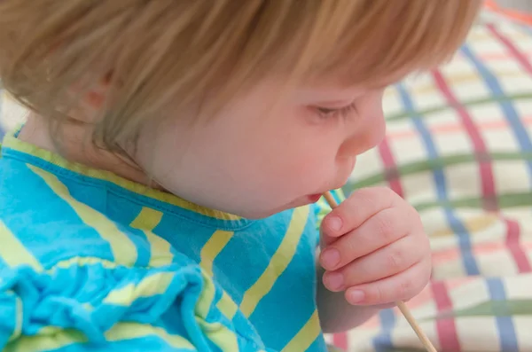 Küçük Kız Bir Çocuk Bir Çubuğa Karamelli Şeker Yiyor — Stok fotoğraf