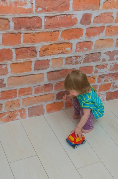 Kırmızı Tuğla Duvar Arka Plan Üzerinde Küçük Kız Çocuk Çalış — Stok fotoğraf