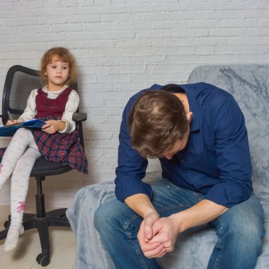 Odadaki psikoloğun resepsiyonunda bir adam ve bir çocuk...