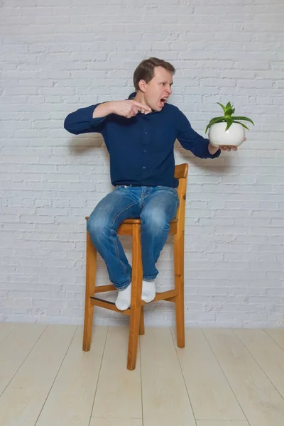 Mężczyzna na drewnianym krześle z kwiatem emocji — Zdjęcie stockowe