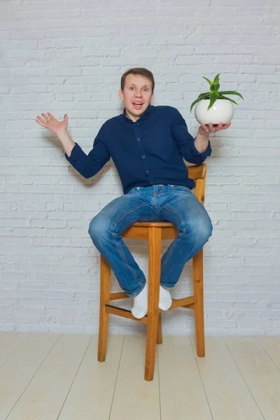 Man op een houten stoel met een bloem van emotie — Stockfoto