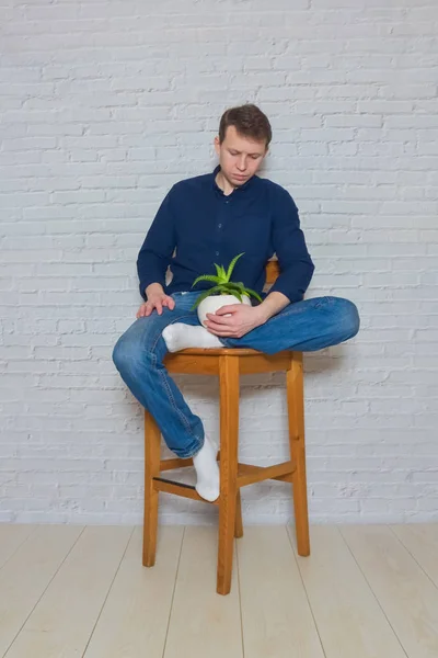 男人坐在木制的椅子上，有一朵感情的花 — 图库照片