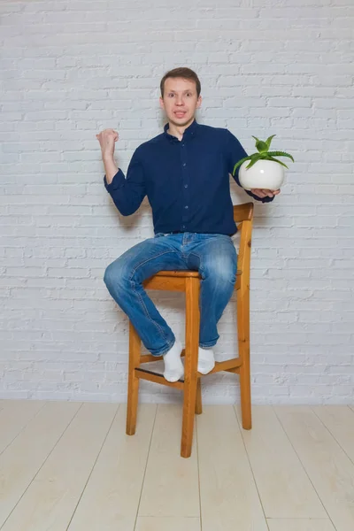 Man op een houten stoel met een bloem van emotie — Stockfoto