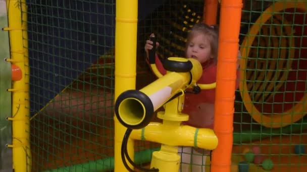 A criança menina no Playground atira bolas de um canhão — Vídeo de Stock