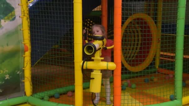 Het meisje kind op de speelplaats schiet ballen uit een kanon — Stockvideo