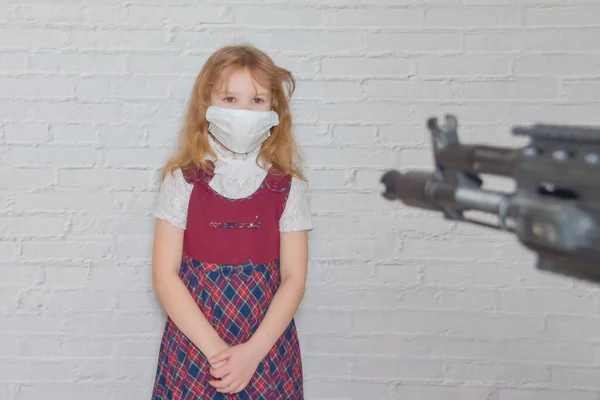 the girl with a gun and a mask on her face during the epidemic