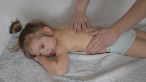 Een arts heeft een kind op de massagetafel op de ingreep — Stockvideo