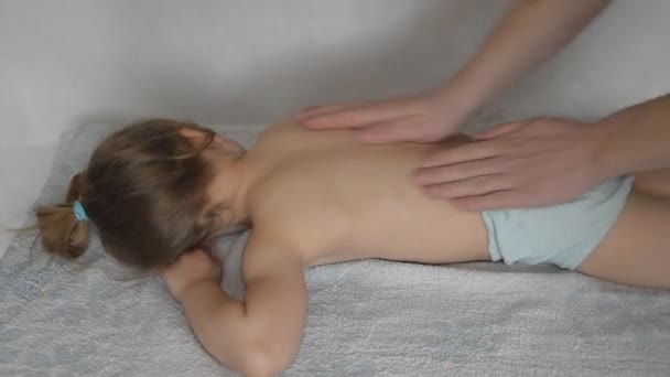 Um médico tem uma criança na mesa de massagem sobre o procedimento — Vídeo de Stock