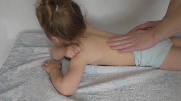 Врач имеет ребенка на массажном столе на процедуре — стоковое видео