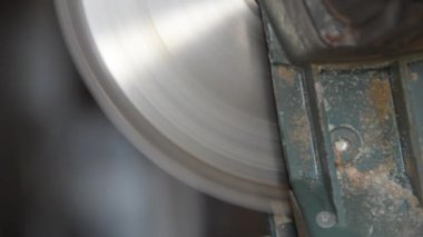 Disk buduyor, erkek işçi testereyle kesiyor.