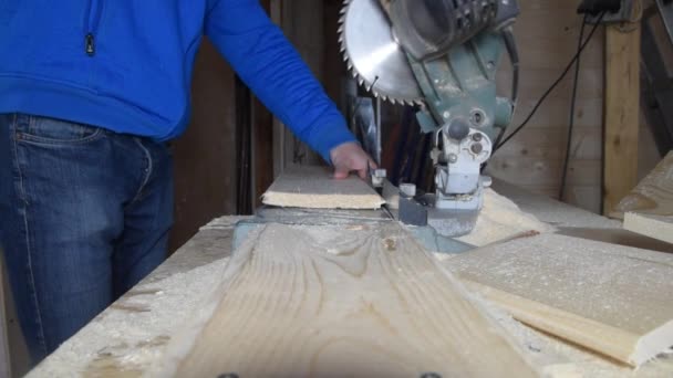 Un ouvrier mâle taille disque coupe scie une planche de la taille — Video