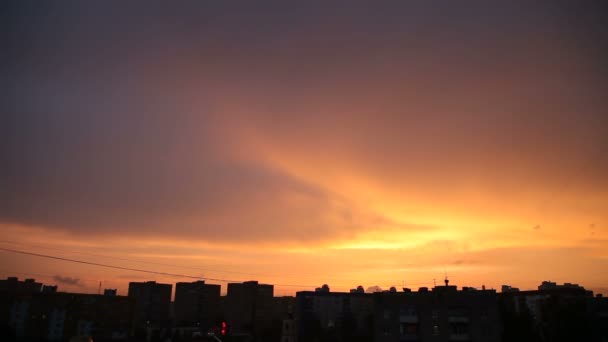 Idő telik klip naplemente a városban. Bolyhos színes felhők felett fekete körvonal épületek. Gyönyörű cloudscape. — Stock videók