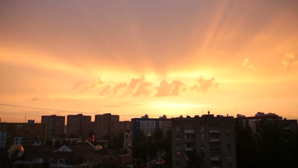 Tijd lapse clip van zonsondergang in de stad. Pluizige kleurrijke wolken over zwarte contouren van gebouwen. Mooie cloudscape. — Stockvideo