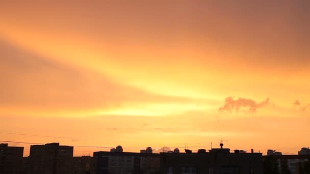 Tijd lapse clip van zonsondergang in de stad. Pluizige kleurrijke wolken over zwarte contouren van gebouwen. Mooie cloudscape. — Stockvideo