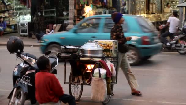 Siem Reap, Kambodża - Marzec 8, 2013. Życie ulicy w Siem Reap. Ruchu drogowego i spacerów gdańszczan. Kobieta sprzedaje gotowana kukurydza na mały zasobnik. — Wideo stockowe