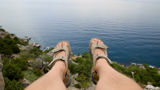 Hombres piernas en los zapatos marrones que yacen en la montaña en el fondo del paisaje marino — Vídeo de stock