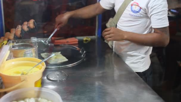 BANGKOK, THAILAND - Homem cozinha panqueca com bananas e leite doce, sobremesa tradicional na Ásia. Pequeno café de rua . — Vídeo de Stock