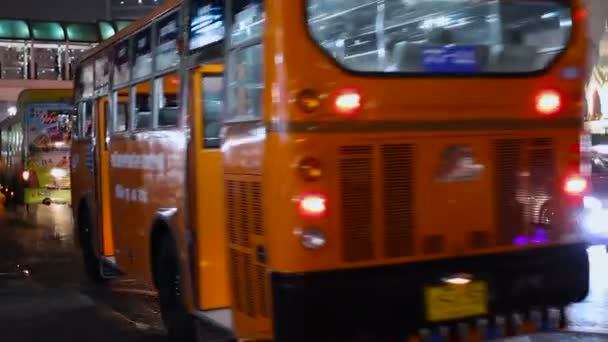 BANGKOK, TAILANDIA - Vida callejera habitual en Bangkok. Tráfico por carretera en la noche. Coches y autobuses . — Vídeos de Stock