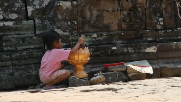 Siem Reap, Kamboçya - 18 Mart 2009. Küçük kız ışıklar sopa ve mumlar tapınağın önünde tütsü. Angkor Wat. — Stok video