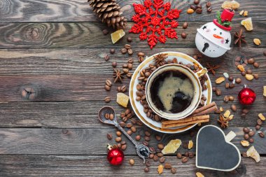 Rustik ahşap arka plan fincan kahve ve yeni yıl süslemeleri ile. Kalp kara tahta şeklinde. Zencefil ve anason ile Noel içecek. Üstten Görünüm, metin için yer.