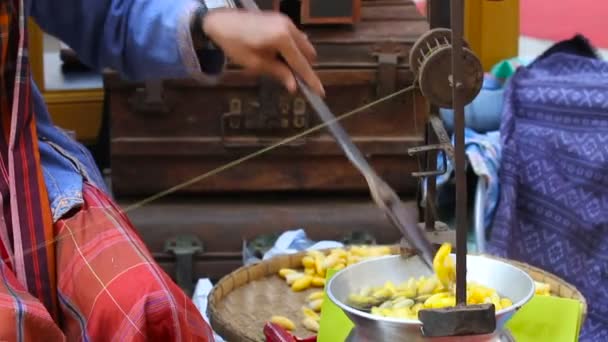 Mujer hierve capullos de gusano de seda y hace un hilo de seda. Fabricación tradicional de tela asiática. Tailandia . — Vídeo de stock