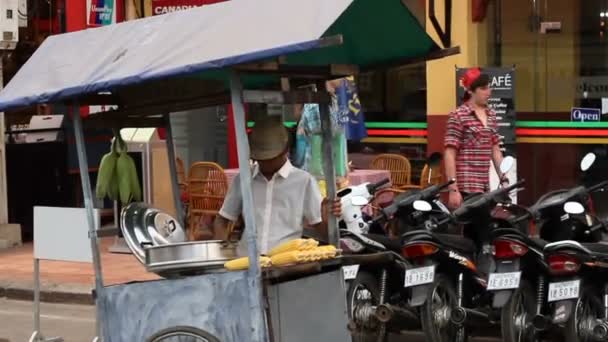 Siem Reap, Kambodża - człowiek z mobilnych wózek sprzedaje gotowanej kukurydzy. Azjatycki fast uliczni. — Wideo stockowe