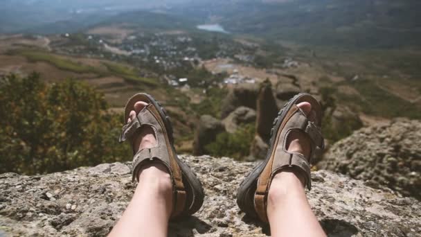 Hombres piernas en los zapatos marrones que yacen en las rocas en el fondo de la montaña — Vídeos de Stock