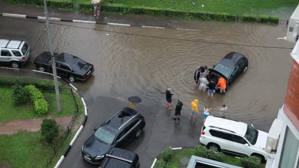 ODINTSOVO, RUSIA - 07 de julio de 2013. La gente está tratando de salvar el coche del agua después de una fuerte lluvia. Vista aérea . — Vídeo de stock