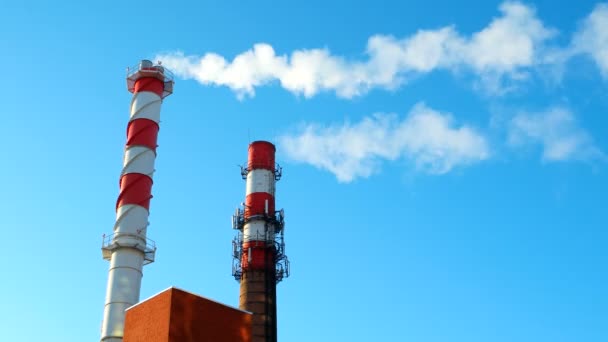 Chaminé da casa da caldeira. Vapor contra o céu azul claro. Zona industrial da cidade . — Vídeo de Stock