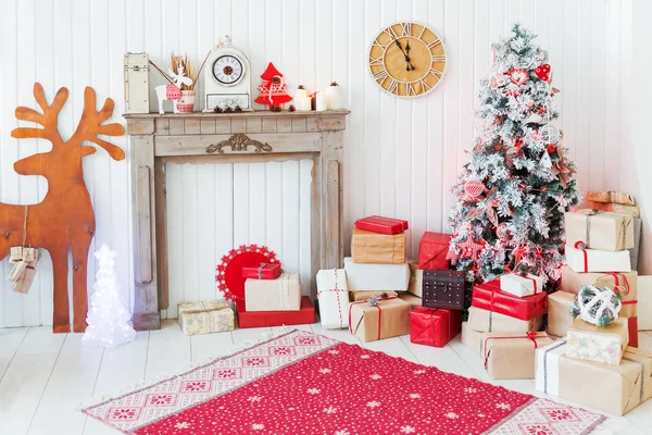 Noël et Nouvel An détails de l'intérieur de la maison cerf en bois, cheminée avec bougies, arbre Eve et cadeaux . — Photo