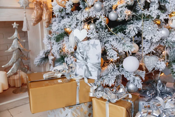Jule- og nyttårsbakgrunn med gaver under treet. Juledags vinterbakgrunn. Mange gaver pakket i gull- og sølvpapir med sløyfer . – stockfoto