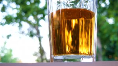 Hava kabarcıkları limonata cam kadar yükselir. Yeşil yaprakları ve soğuk içecek ile yaz arka plan.