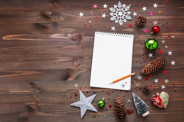 Christmas and New Year background with notepad, pencil and decorations.