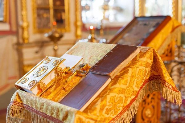 Golden religious utensils - Bible, cross, prayer book, missal . Details in the Orthodox Christian Church. Russia. — Stock Photo, Image