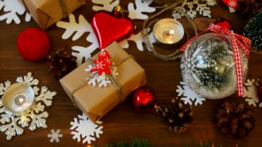 Noel ve yeni yıl arka plan sunar, ışıklar, mumlar ve farklı süslemeler ile. Kraft kağıt kızıl çam ağacı ile hediye.