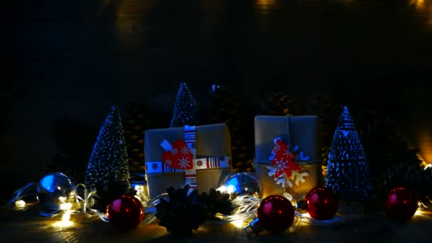 Fondo de Navidad y Año Nuevo con regalos. Los regalos envueltos en el papel artesanal con los símbolos de fiesta - el corazón y el abeto. Nieve cae desde arriba . — Vídeo de stock