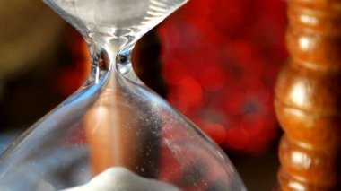 Noel ve yeni yıl arka plan sunar, kurdeleler, topları ve ahşap arka plan üzerinde farklı yeşil süslemeleri ile. Ahşap kum saati önlemler zaman tatil kadar.